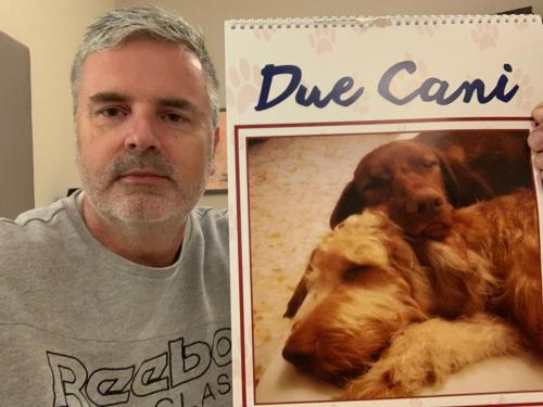 a man holding up a picture of a dog at Due Cani Apartment in Palermo