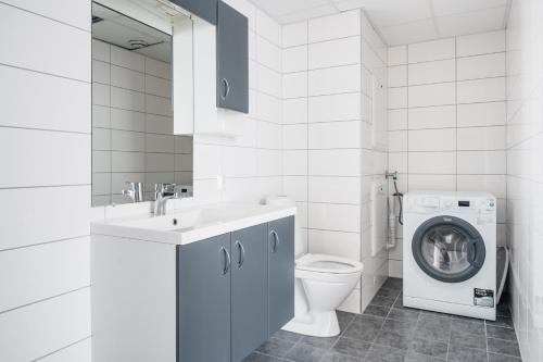 a white bathroom with a washing machine and a washer at Stay Urban - Scandinavian Comfort with Private Balcony in Bergen