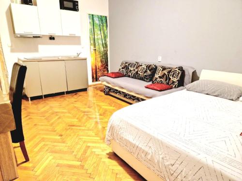a bedroom with a bed and a couch at Central Jardin Guest House Split in Split