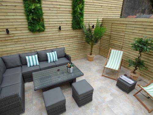 a patio with a couch and a table and chairs at Historic City Centre Town House in Chester