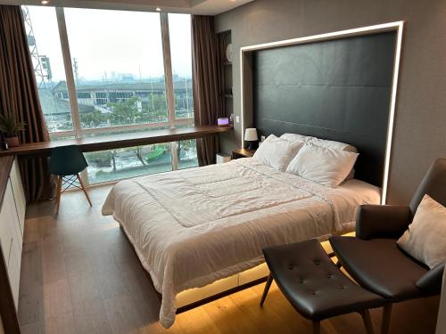 1 dormitorio con cama y ventana grande en U Residence 2 Studio Apartment POOL VIEW, en Tangerang