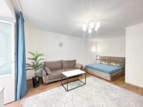 a living room with a couch and a bed at 1 кімнатні просторі апартаменти біля Сіті- центру 2 поверх 9 поверхового будинку in Mykolaiv