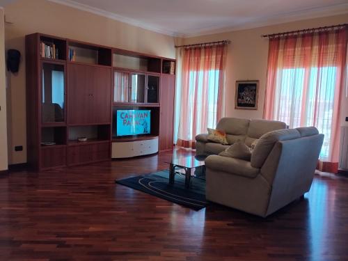 ein Wohnzimmer mit einem Sofa und einem TV in der Unterkunft I GIRASOLI Short Rent in Palermo