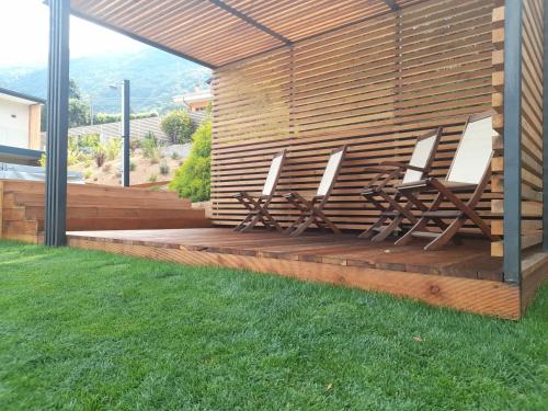 a group of chairs sitting on a wooden deck at d'Ocalée Holiday Experience lago d'Orta in Omegna