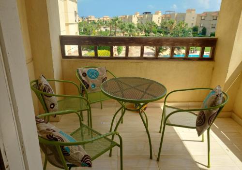 balcón con mesa, sillas y ventana en شاليه قرية مرسيليا بيتش 3 مارسيليا عائلات فقط - Marseilia Beach 3 chalet Families Only, en Dawwār Muḩammad Abū Shanab