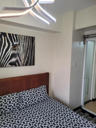 - une chambre avec un lit et un ventilateur de plafond dans l'établissement Juja's place, à Manille