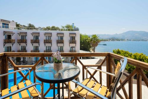 a table and chairs on a balcony with a view of the water at Elite Hotel Yalıkavak in Yalıkavak