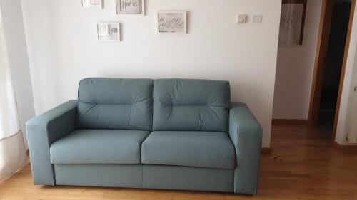 a blue couch sitting in a living room at El Llano 3 in Puebla de Alfindén