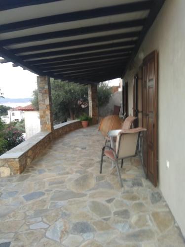 a patio with a table and chairs under awning at Κατηγιώργης Ξενώνας Ρεγγίνα in Agios Georgios