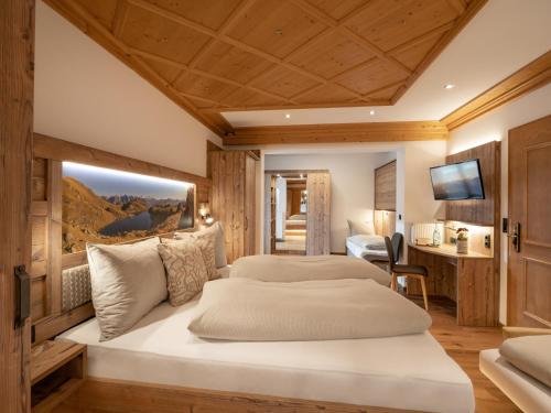 a bedroom with two beds and a television in a room at Hotel Garni Ferienhof in Mayrhofen