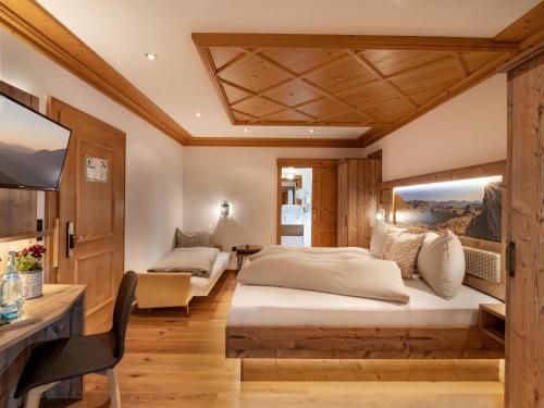 a bedroom with two beds and a desk at Hotel Garni Ferienhof in Mayrhofen