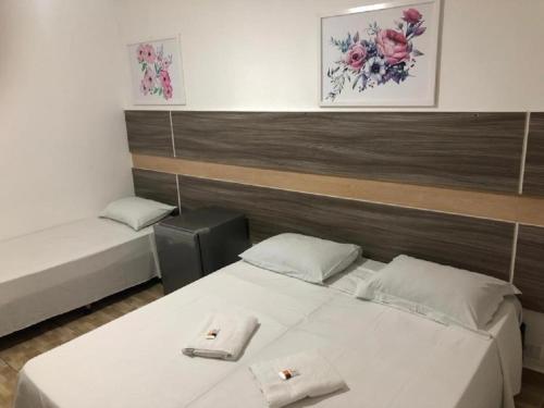 ein Zimmer mit 2 Betten und Handtüchern darauf in der Unterkunft Hotel Natal in Santos