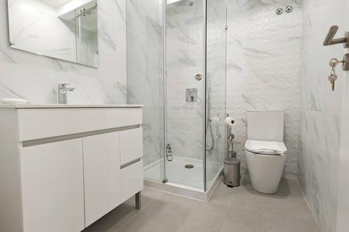 a white bathroom with a shower and a toilet at Jerónimos Apartments best place in Lisbon - 1º D in Lisbon