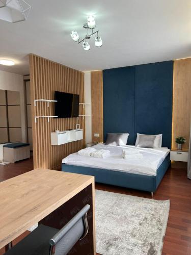 a bedroom with a large bed and a television at Altai Apartments in Astana