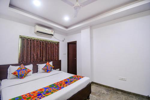 um quarto com uma cama grande e almofadas coloridas em FabHotel Rani Tower em Calcutá