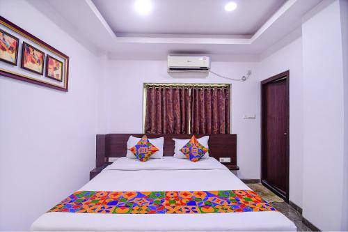 a bedroom with a large bed with colorful sheets and pillows at FabHotel Rani Tower in Kolkata
