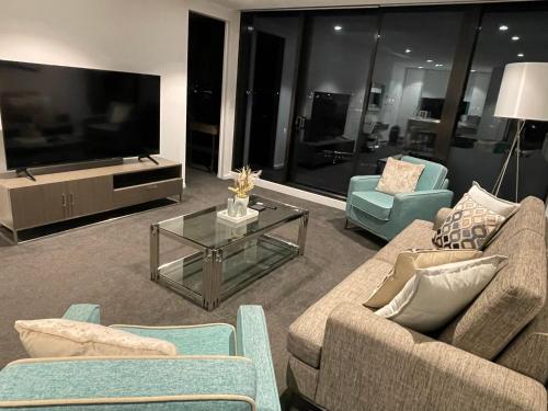 a living room with two couches and a tv at Fantastic 3 Bedroom Apartment in Southbank in Melbourne