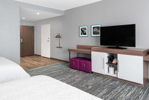 a bedroom with a bed and a flat screen tv at Hampton Inn & Suites Bridgeview Chicago, Il in Bridgeview