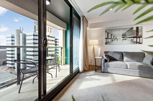 a living room with a couch and a table at Lily - North Terrace Cityscape Residence in Adelaide