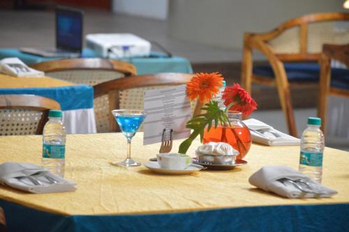 a table with a blue table cloth with a vase of flowers at Lords Eco Inn Belagavi in Belgaum