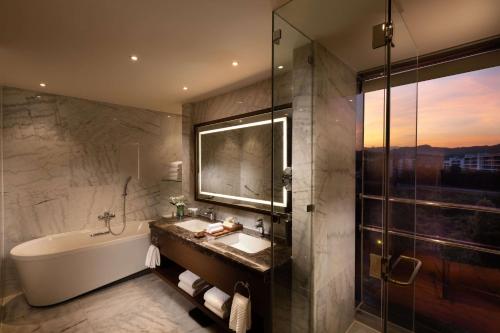 a bathroom with a tub and a sink and a shower at Hilton Clark Sun Valley Resort in Clark