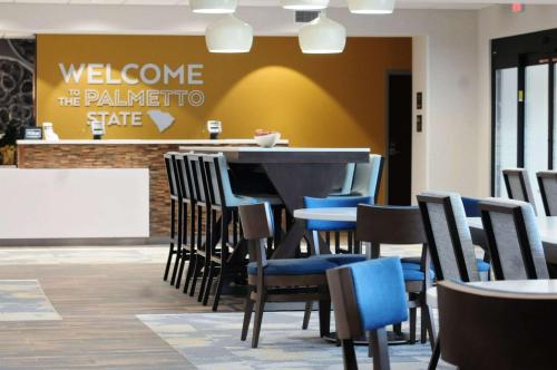 a restaurant with chairs and a table with a welcome sign at Hampton Inn Camden, SC in Camden
