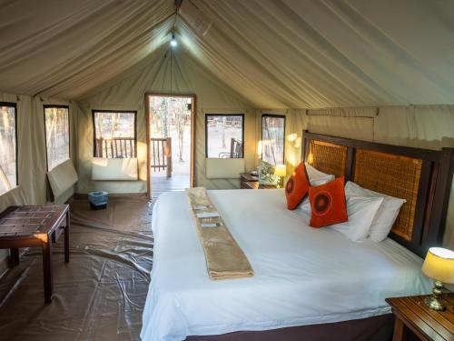 - une chambre avec un grand lit dans une tente dans l'établissement Buffalo Rock Tented Camp, à Hazyview