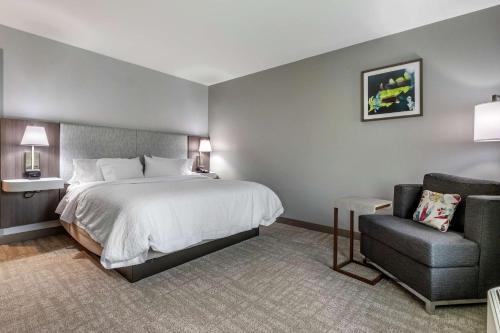 a hotel room with a bed and a chair at Hampton Inn Camden, SC in Camden