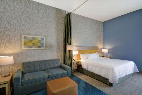 a hotel room with a bed and a couch at Home2 Suites By Hilton Dayton South in Miamisburg