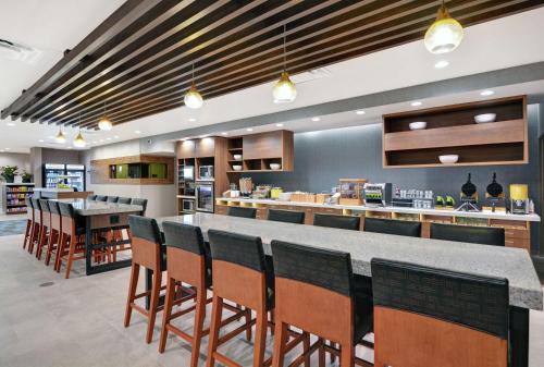 a restaurant with a bar with chairs and a counter at Home2 Suites By Hilton Bettendorf Quad Cities in Bettendorf