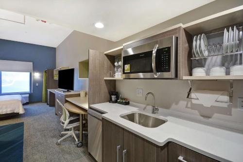 a kitchen with a sink and a desk in a room at Home2 Suites By Hilton Dayton South in Miamisburg