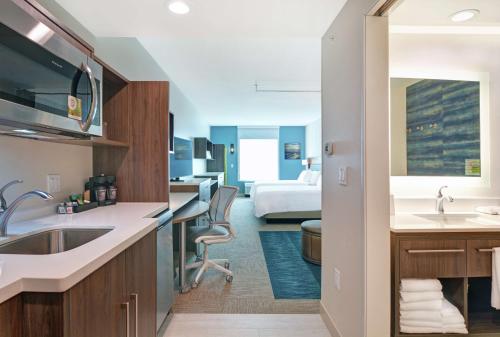 a hotel room with a kitchen and a bedroom at Home2 Suites By Hilton Bettendorf Quad Cities in Bettendorf