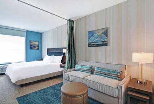 een hotelkamer met een bed en een bank bij Home2 Suites By Hilton Bettendorf Quad Cities in Bettendorf