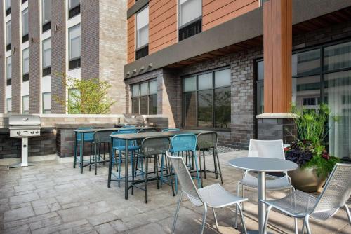 a patio with tables and chairs and a grill at Home2 Suites By Hilton Madison Central Alliant Energy Center in Madison