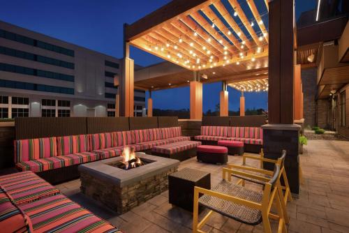 d'un toit-terrasse avec des canapés rouges et un foyer extérieur. dans l'établissement Home2 Suites By Hilton Madison Central Alliant Energy Center, à Madison