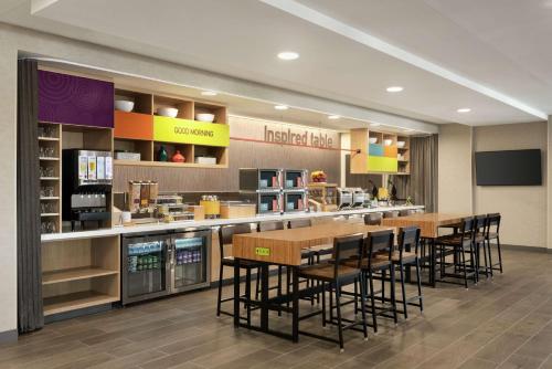 a restaurant with tables and chairs in a cafeteria at Home2 Suites By Hilton Madison Central Alliant Energy Center in Madison