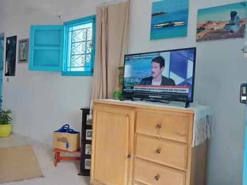 einen Fernseher auf einer Kommode in einem Zimmer in der Unterkunft Bungalow Djerbien in Midoun