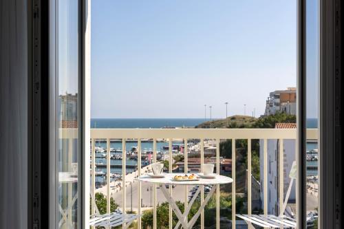 a balcony with a table and a view of a harbor at Marea Charme Rooms in Vieste