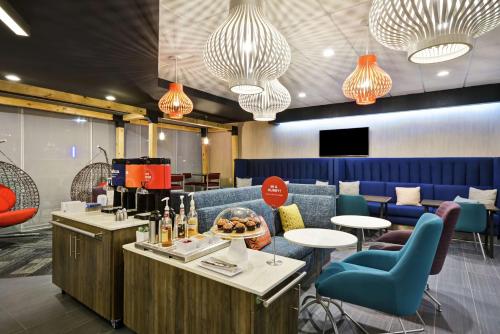 a restaurant with a bar with blue chairs and tables at Tru By Hilton Corpus Christi South Padre Island Dr in Corpus Christi