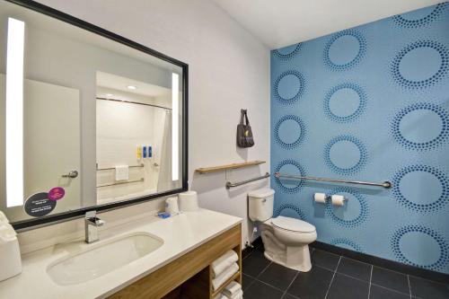 a bathroom with a sink and a toilet and a mirror at Tru By Hilton Corpus Christi South Padre Island Dr in Corpus Christi