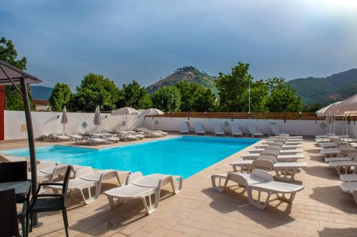 uma piscina com espreguiçadeiras e um monte de móveis em I Milord 2 em Castel San Giorgio