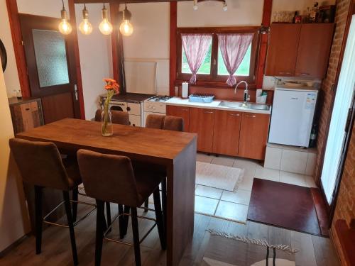 a kitchen with a wooden table with chairs and a refrigerator at Kuća za odmor Čanić gaj in Gospić