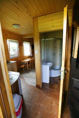 a bathroom with a tub and a sink in a room at Domki ELDORADO in Dębki