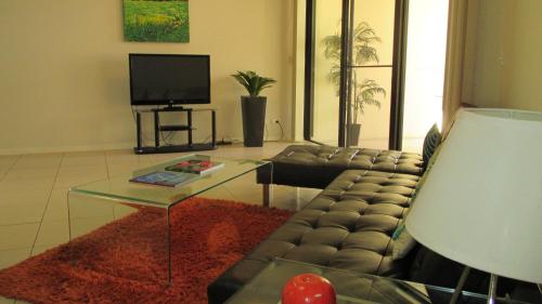 a living room with a couch and a coffee table at Edge Apartments Cairns in Cairns