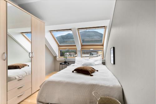a bedroom with a large bed with two windows at Beautiful apartment with 3 bedrooms in Sogndal