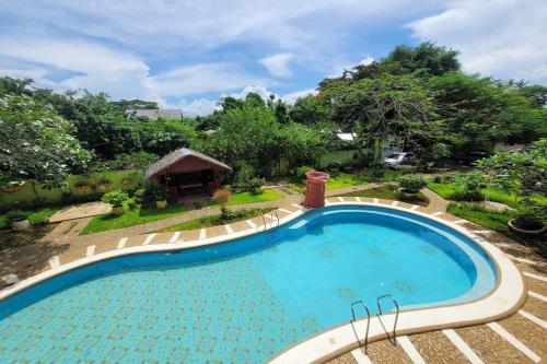 a large swimming pool in a yard with trees at Hanbee's Resort in Puerto Princesa City