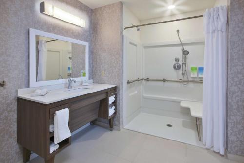 y baño con lavabo, bañera y ducha. en Home2 Suites By Hilton West Bloomfield, Mi, en North Farmington