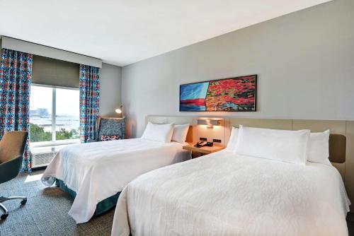 een hotelkamer met 2 bedden en een raam bij Hilton Garden Inn Biloxi in Biloxi