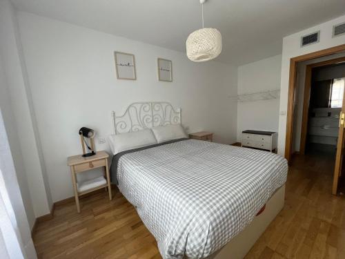 a bedroom with a bed with a black and white comforter at El Llano 3 in Puebla de Alfindén