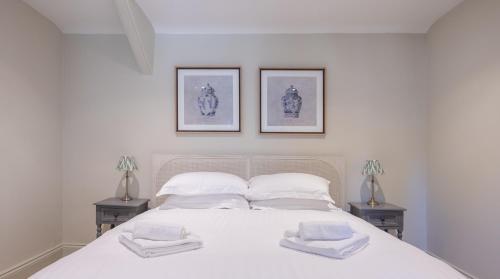 a bedroom with a white bed with two night stands at Cunsey Mill House in Far Sawrey